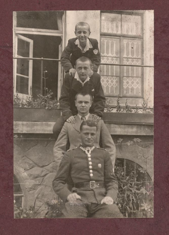 Bracia Kostiuk, od góry: Jerzy, Jan, Marian, Zygmunt, w tle dom ul. 29 Listopada 69, Lwów, około 1939 r.